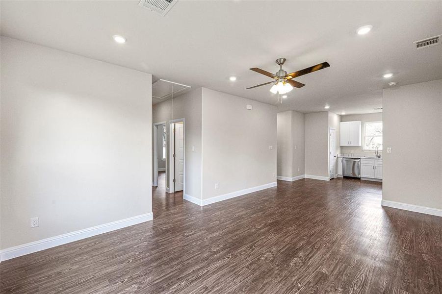 Unfurnished living room featuring dark hardwood / wood-style floors, ceiling fan, and sink