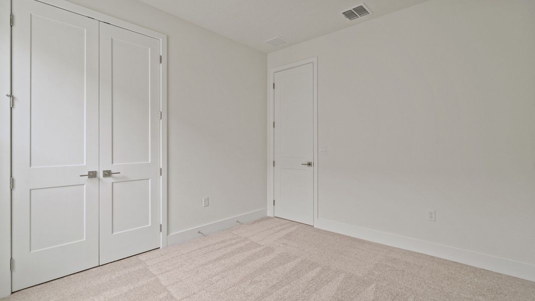 Secondary Bedroom with a spacious closet of the Buttonwood by DRB Homes at Trailside in Mount Dora, FL.