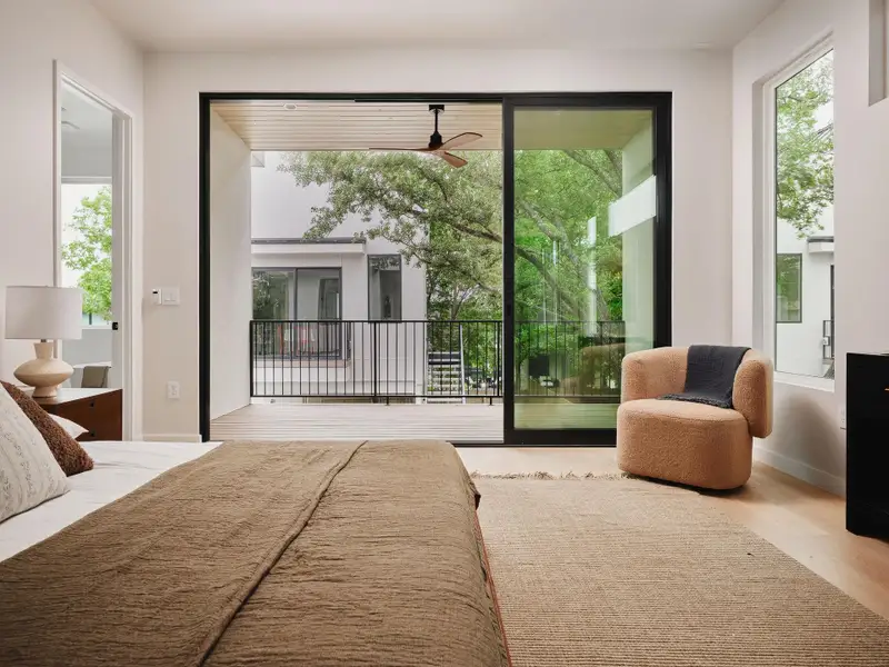 Spacious room featuring a wide sliding glass door opening to a private balcony with black metal railing