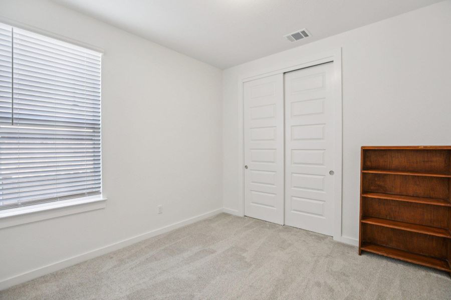 Unfurnished bedroom with carpet and a closet Unfurnished bedroom with carpet and a closet