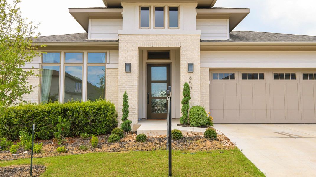 Modern facade with brick and siding accents, offering a welcoming entrance and an integrated garage. Modern facade with brick and siding accents, offering a welcoming entrance and an integrated garage.