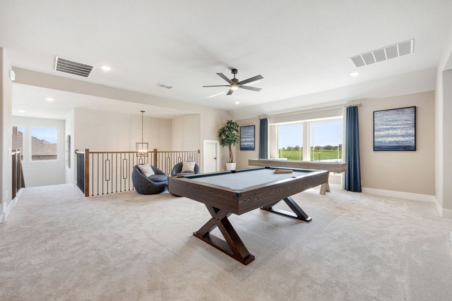 Upstairs bonus room with pool table, carpet flooring, ceiling fan, and open staircase railing