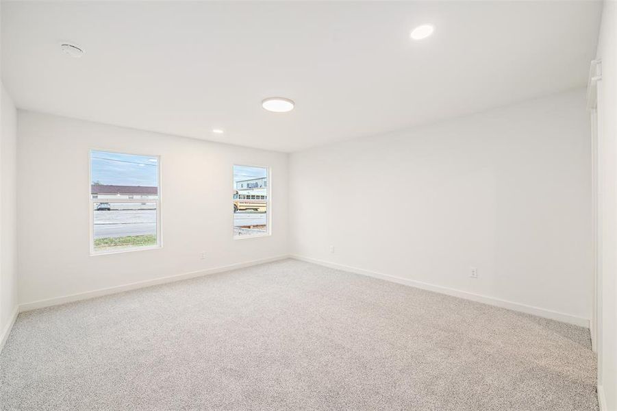 Carpeted empty room with recessed lighting and baseboards