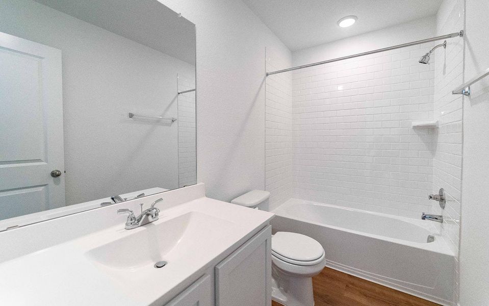 Full bathroom featuring vanity, dark wood-style flooring, and shower combination Full bathroom featuring vanity, dark wood-style flooring, and shower combination