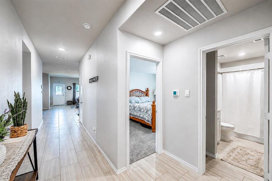 Hallway featuring wood-finish tile flooring, recessed lighting, and a white interior door