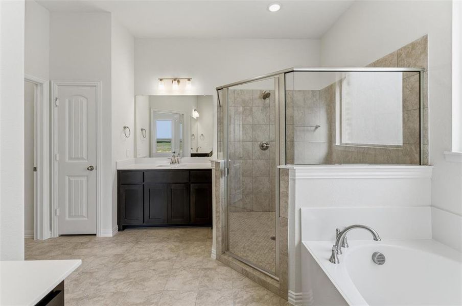 Full bathroom featuring vanity, a bath, a shower stall, and light tile patterned floors