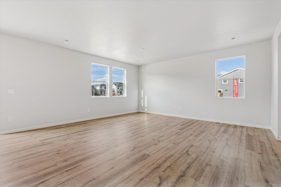 A room with a wood floor and a wood floor with a window.