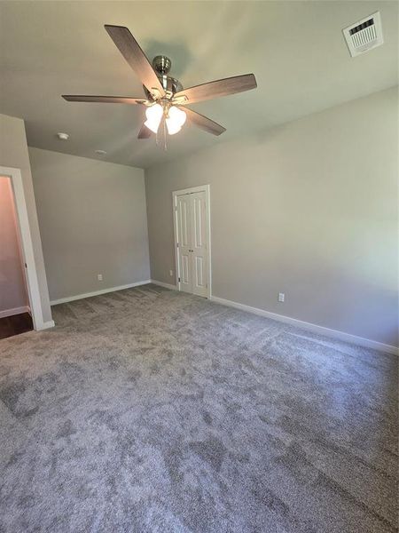 Carpeted empty room with ceiling fan