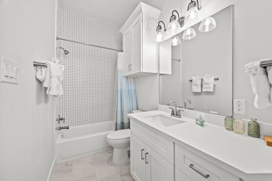 The junior suite is complemented by a private ensuite, where the penny tile adds a striking pop of character to the space.
