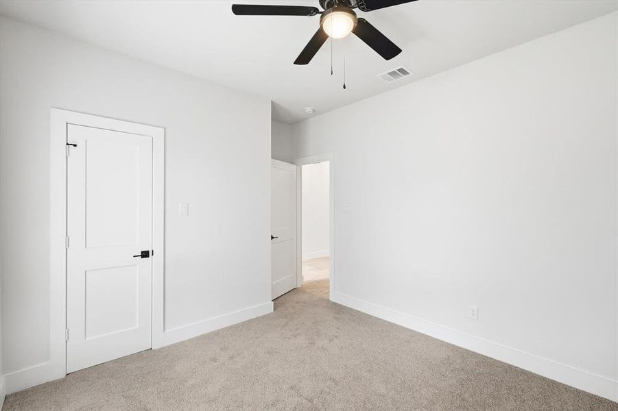 Unfurnished bedroom with carpet flooring and ceiling fan