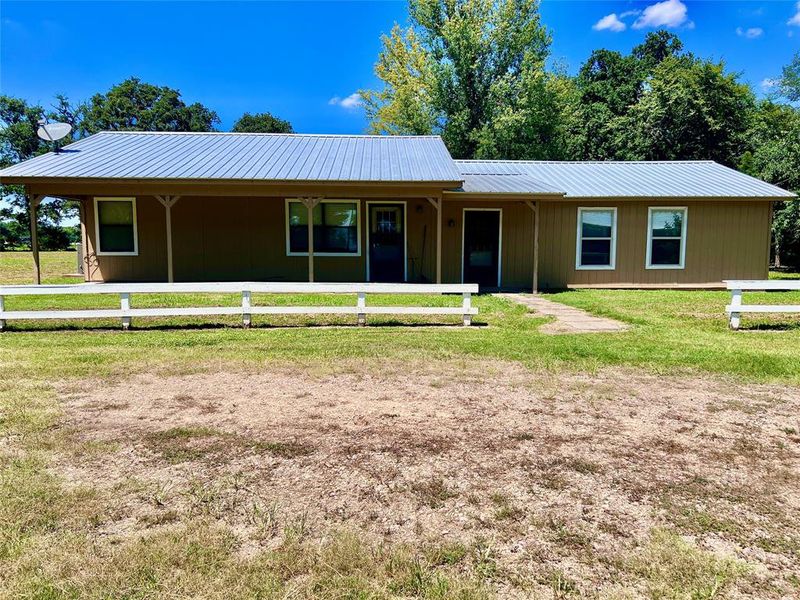 View of front of property with a front lawn and a metal roof View of front of property with a front lawn and a metal roof