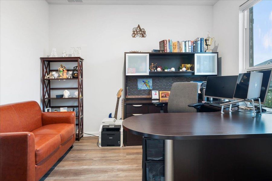 Office area with light wood finished floors and healthy amount of natural light