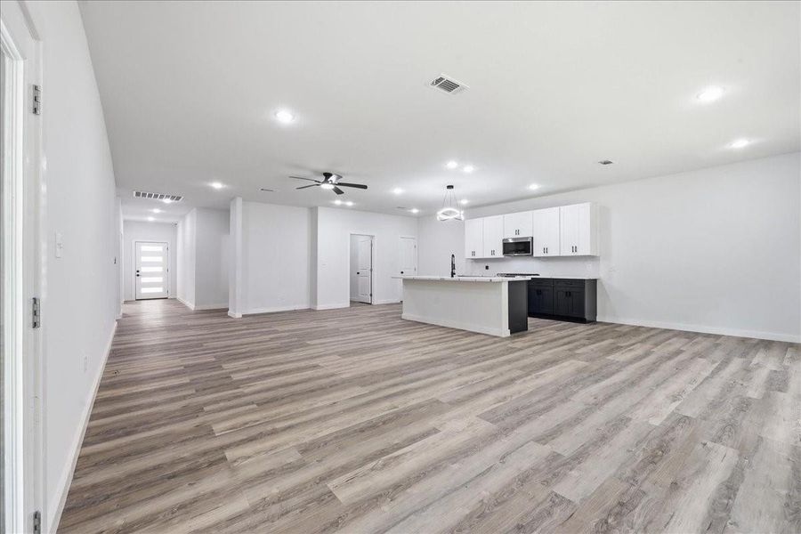Bright and airy main living room featuring high ceilings, recessed lighting, and a modern ceiling fan. Bright and airy main living room featuring high ceilings, recessed lighting, and a modern ceiling fan.