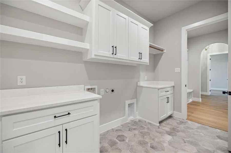 Washroom featuring cabinets, hookup for a washing machine, light hardwood / wood-style floors, and electric dryer hookup