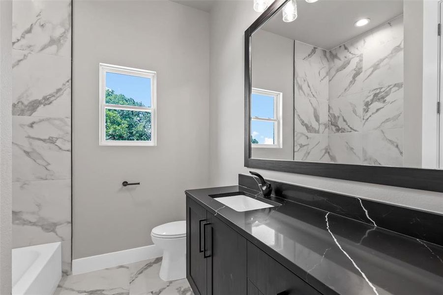 Bathroom featuring vanity, toilet, plenty of natural light, and tile patterned flooring