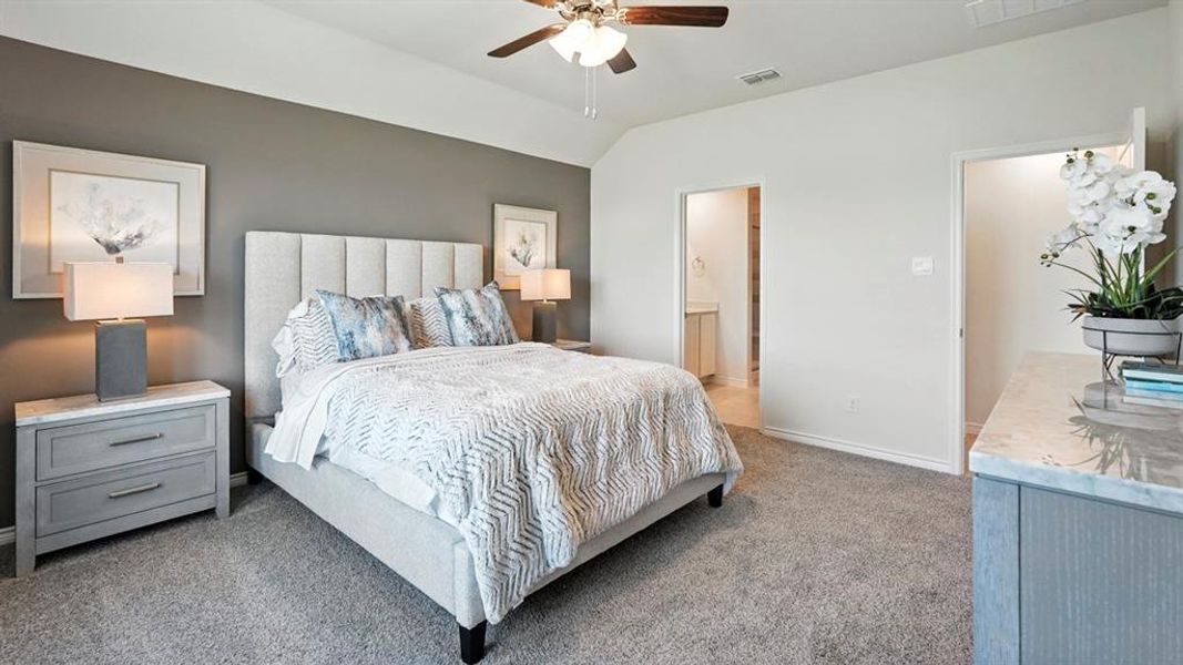 Bedroom with light colored carpet, lofted ceiling, a ceiling fan, and connected bathroom