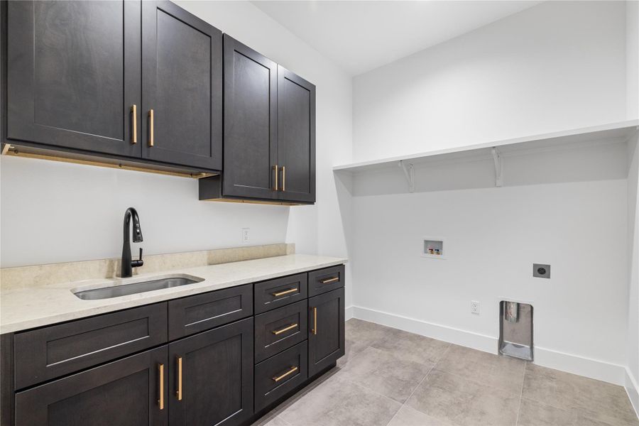 Laundry room with plenty of cabinet space, washer hookup, electric dryer hookup, and light tile floors Laundry room with plenty of cabinet space, washer hookup, electric dryer hookup, and light tile floors