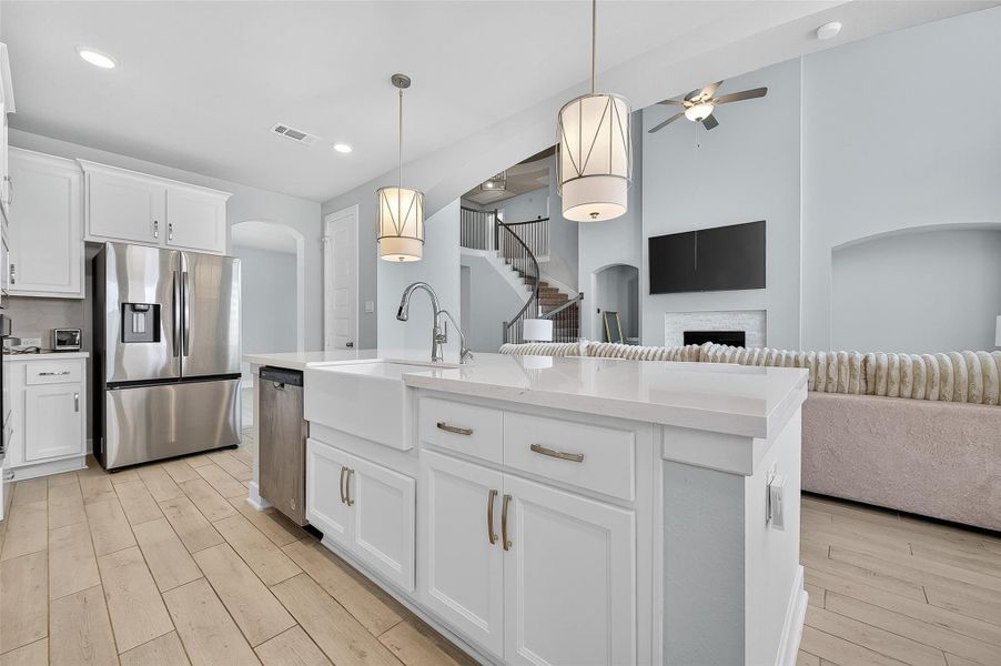 A smooth flow from kitchen to great room makes this the ideal setup for gatherings and everyday life. Chic white cabinetry and a large sink island balance form and function.