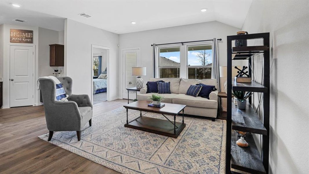 Bright living area with vaulted ceilings and wood-finish flooring