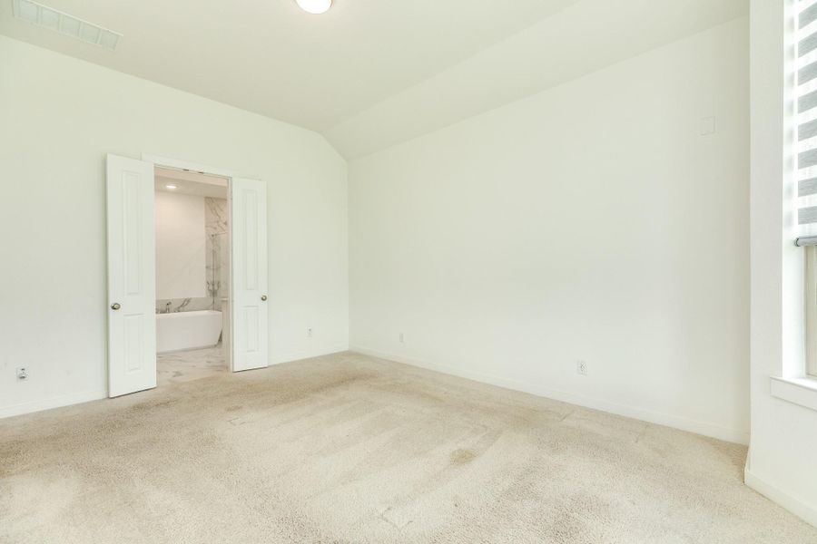 This image features the entrance to the primary bathroom, which is highlighted by elegant double doors.