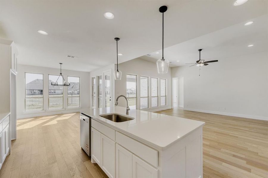 Kitchen featuring white cabinetry, open floor plan, and light wood-style flooring