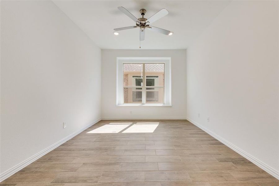 Empty room with light hardwood / wood-style flooring and ceiling fan