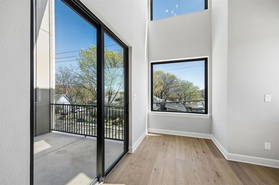 Doorway to outside with wood-type flooring, a high ceiling, and plenty of natural light Doorway to outside with wood-type flooring, a high ceiling, and plenty of natural light