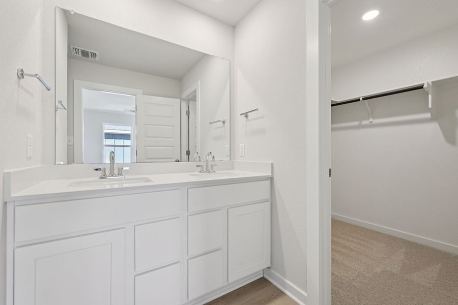 A bathroom with white cabinets.