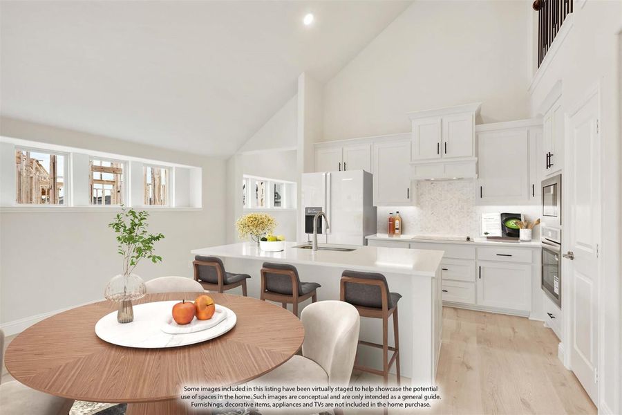 Open-concept kitchen and dining area with white cabinets, large island, vaulted ceiling, and light hardwood floors