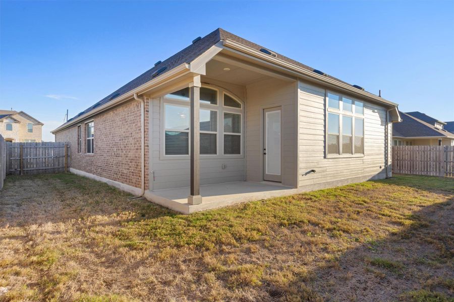 Rear view of property with a fenced backyard, a patio area, and brick siding