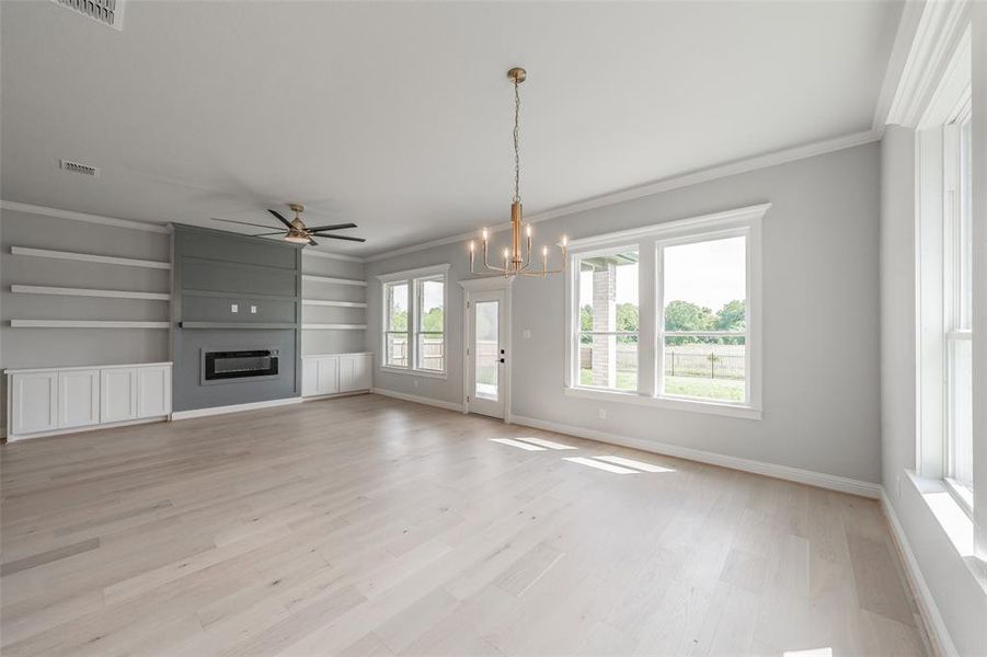 Huge living room features an electric fireplace & built in cabinets & shelving