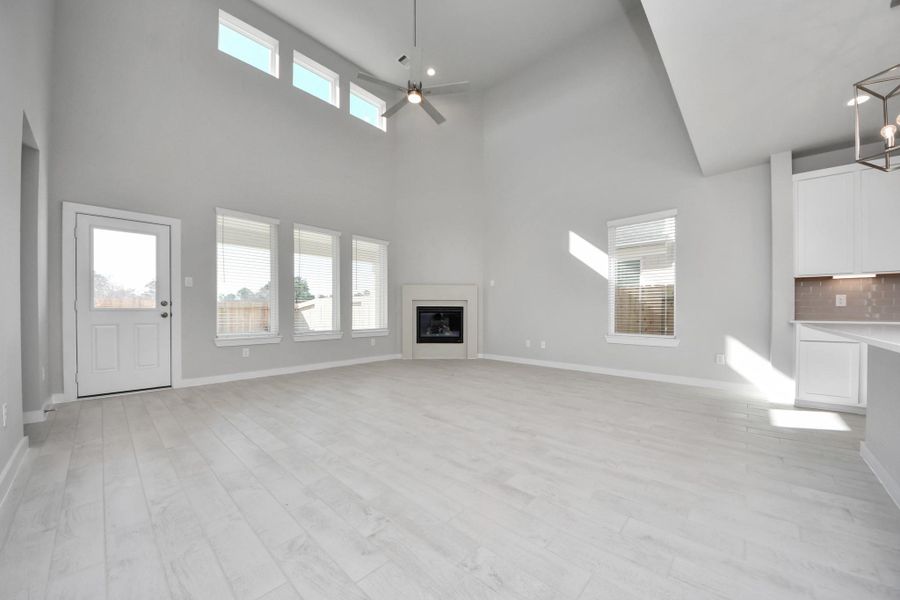 Welcome family and guests to your charming living room! With its high ceilings, recessed lighting, ceiling fan, custom paint, beautiful flooring, and large windows that let in abundant natural light, this room is perfect for gatherings. Sample photo of completed home with similar floor plan. Actual colors and selections may vary. Welcome family and guests to your charming living room! With its high ceilings, recessed lighting, ceiling fan, custom paint, beautiful flooring, and large windows that let in abundant natural light, this room is perfect for gatherings. Sample photo of completed home with similar floor plan. Actual colors and selections may vary.