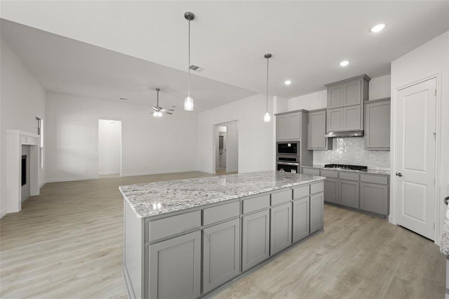 Kitchen with gray cabinets, stainless steel appliances, decorative backsplash, a kitchen island, and recessed lighting Kitchen with gray cabinets, stainless steel appliances, decorative backsplash, a kitchen island, and recessed lighting