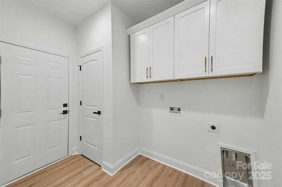 Downstairs laundry right off of garage with storage cabinets and broom closet Downstairs laundry right off of garage with storage cabinets and broom closet