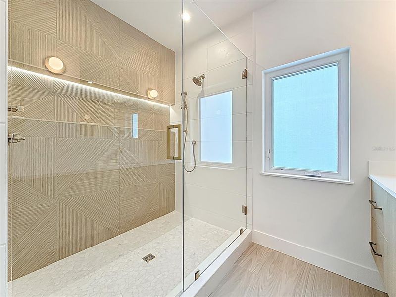 Spa-like en-suite bath featuring dual sinks, an oversized walk-in shower, and a private water closet. Spa-like en-suite bath featuring dual sinks, an oversized walk-in shower, and a private water closet.