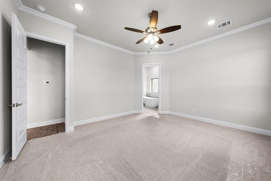 Unfurnished bedroom featuring carpet floors, ornamental molding, recessed lighting, ensuite bathroom, and ceiling fan Unfurnished bedroom featuring carpet floors, ornamental molding, recessed lighting, ensuite bathroom, and ceiling fan