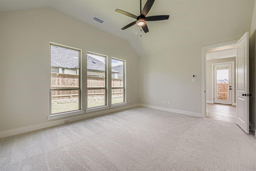 Unfurnished bedroom featuring lofted ceiling, light carpet, and ceiling fan
