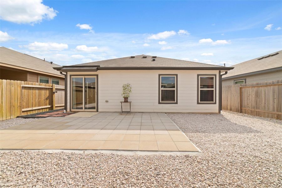 Rear view showcasing the patio area and backyard layout, with plenty of space to relax and enjoy the outdoors.