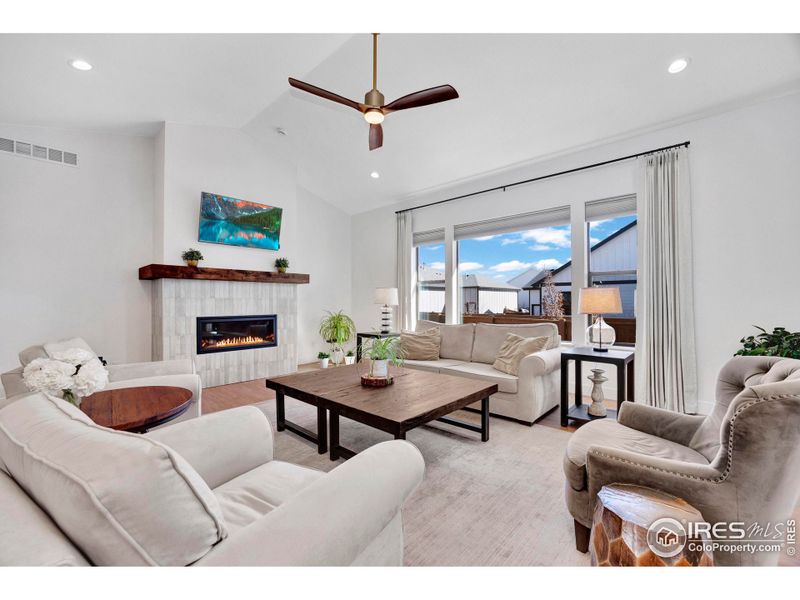 Gas fireplace, large windows and ceiling fan.