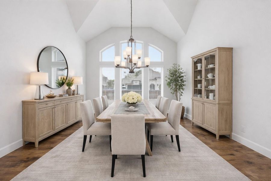 Virtually staged to inspire. Soaring 12-foot vaulted ceilings draw your eyes upward, while the elegant chandelier and arched windows frame the space with effortless grace.