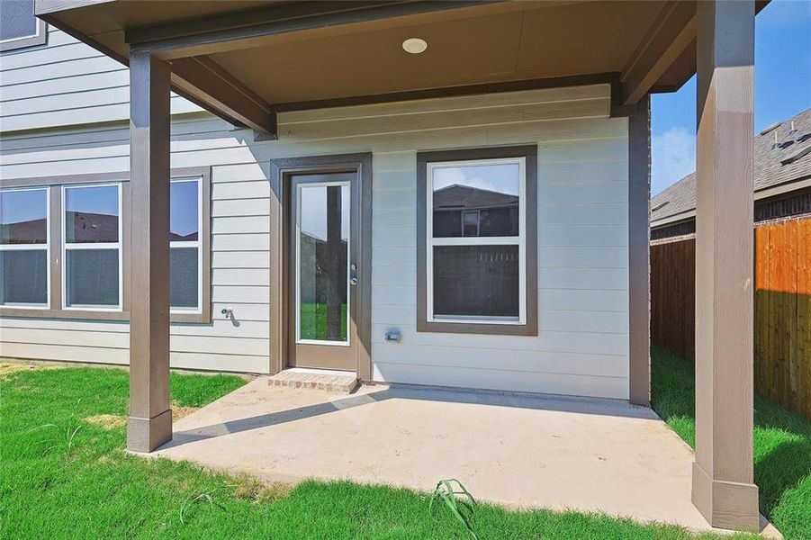 Doorway to property featuring a yard and a patio