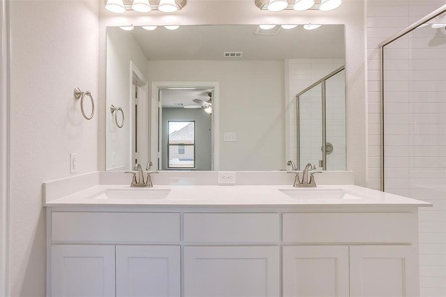 Full bath with a shower stall, double vanity, and ceiling fan Full bath with a shower stall, double vanity, and ceiling fan