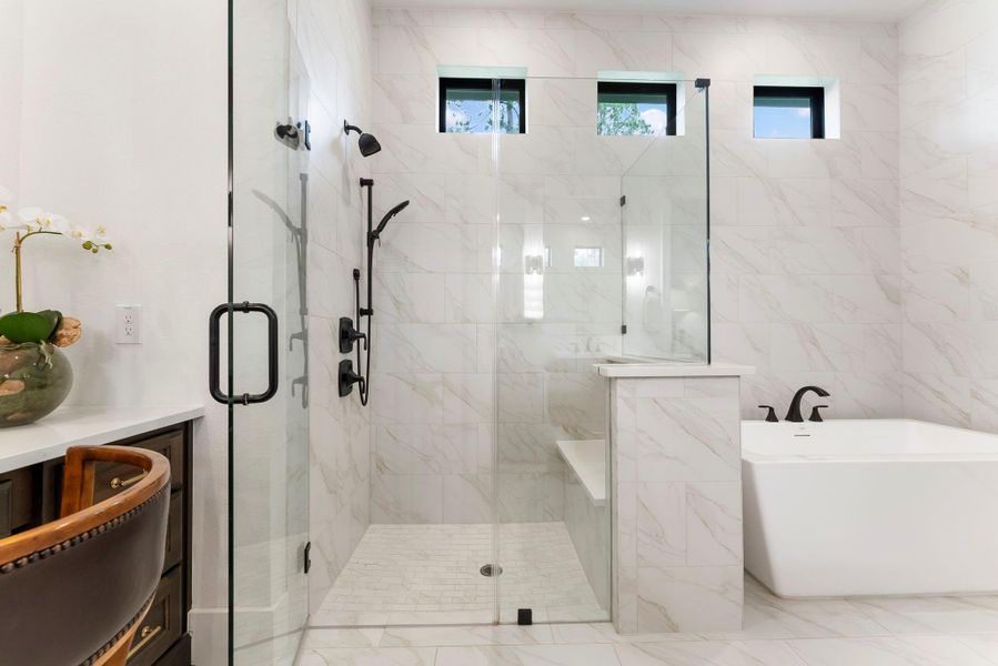 Notice the tile to the ceiling, custom shower seat, and a pony wall added for privacy and function. Its scale and finish selections add to the home’s custom, thoughtfully planned feel.