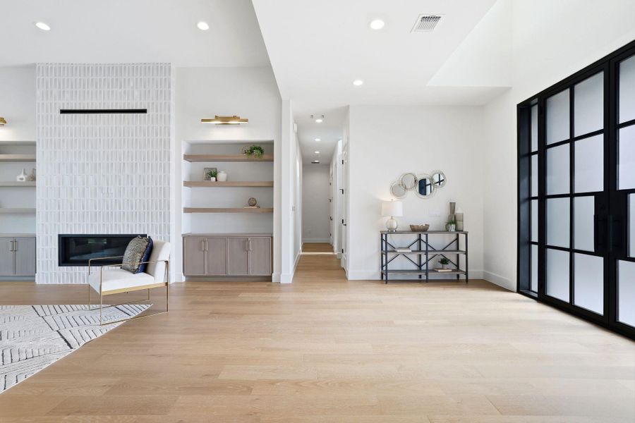 Living area featuring light wood-style floors, a fireplace, and recessed lighting