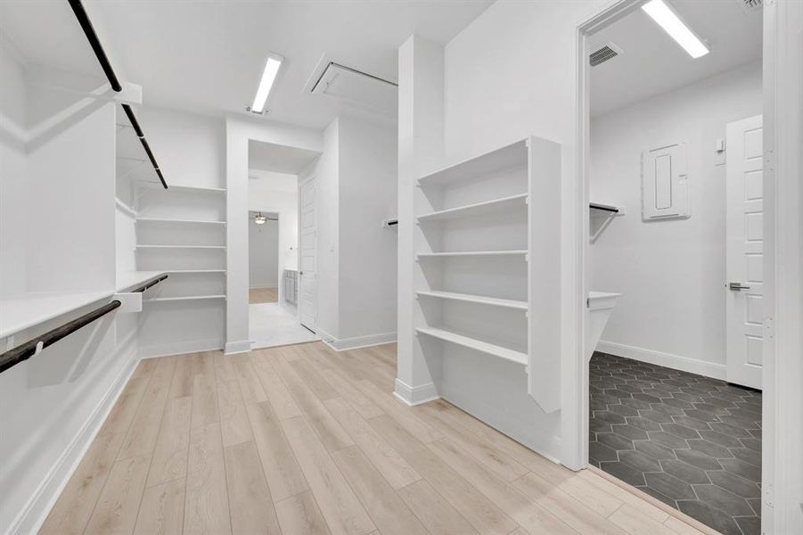 Walk in closet with light wood-style flooring Walk in closet with light wood-style flooring