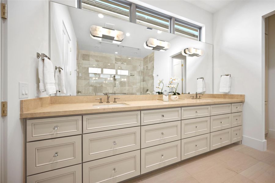 This spacious bathroom features a large double vanity with ample storage, elegant light fixtures, and a modern walk-in shower with glass doors. This spacious bathroom features a large double vanity with ample storage, elegant light fixtures, and a modern walk-in shower with glass doors.