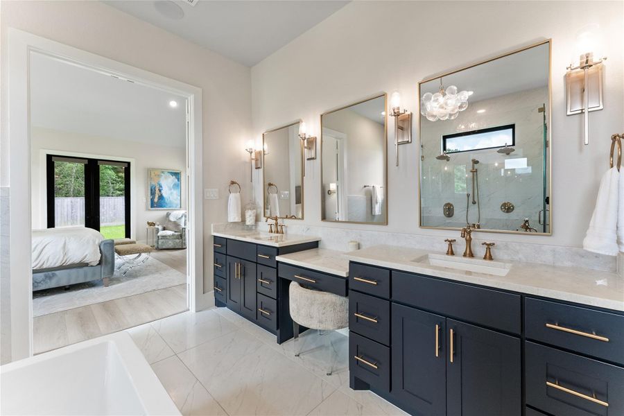 From the bath back into the primary suite, the flow feels private and intentional. The finish palette ties together marble counters, glass, tile, and warm lighting for an elevated daily experience.