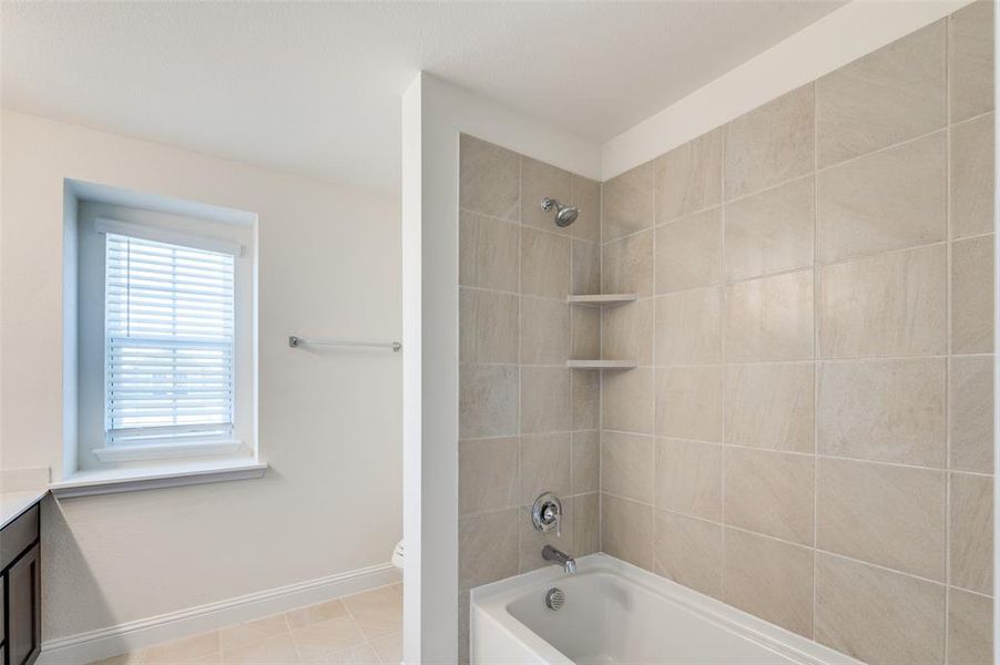 Bathroom with vanity, shower / tub combination, and tile patterned floors