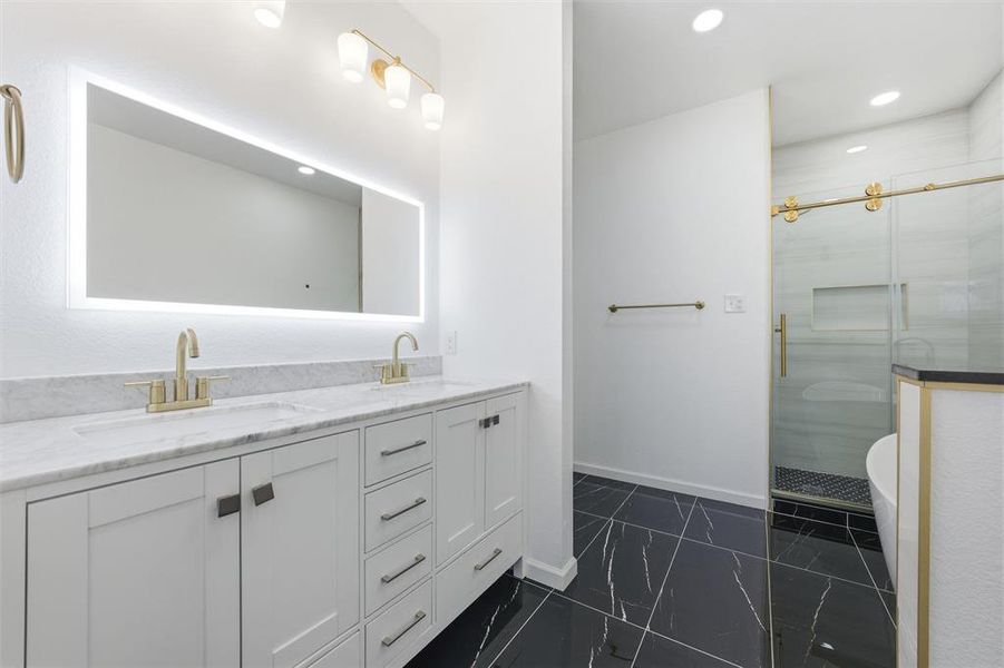Full bathroom featuring a freestanding bath, double vanity, a stall shower, recessed lighting, and dark marble finish floors Full bathroom featuring a freestanding bath, double vanity, a stall shower, recessed lighting, and dark marble finish floors