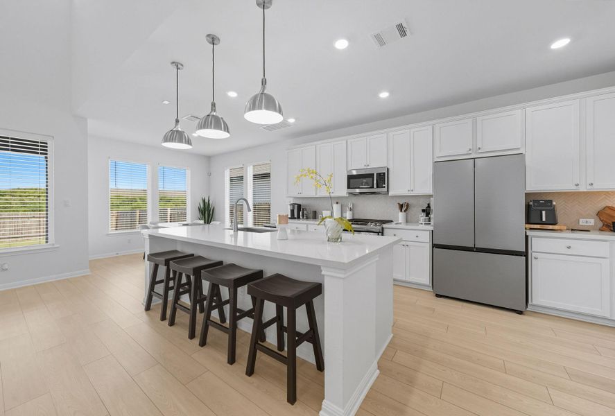 Kitchen featuring decorative backsplash, white cabinets, stainless steel appliances, a breakfast bar, and recessed lighting Kitchen featuring decorative backsplash, white cabinets, stainless steel appliances, a breakfast bar, and recessed lighting